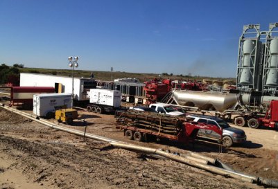 UVX trailer set up on an active frac site beside sand silos and pump trucks