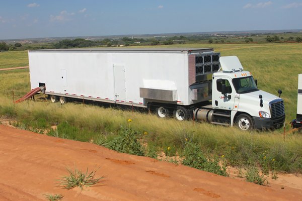 The UVX 100 mobile disinfection trailer on a semi truck in an oilfield