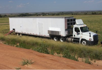UVX 100 trailer and truck parked in the field